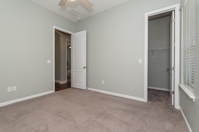 unfurnished bedroom with ceiling fan, light colored carpet, a textured ceiling, and a closet