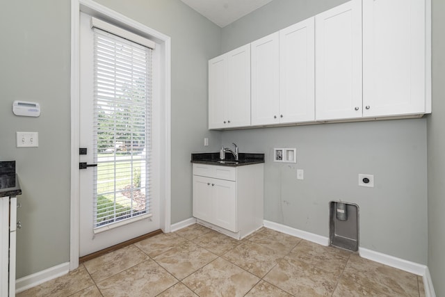 laundry room featuring electric dryer hookup, cabinets, sink, hookup for a washing machine, and light tile patterned flooring