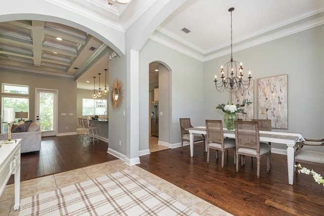 dining room with coffered ceiling, beamed ceiling, hardwood / wood-style floors, a chandelier, and ornamental molding