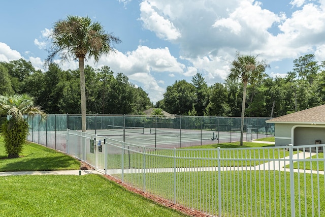 view of tennis court featuring a yard