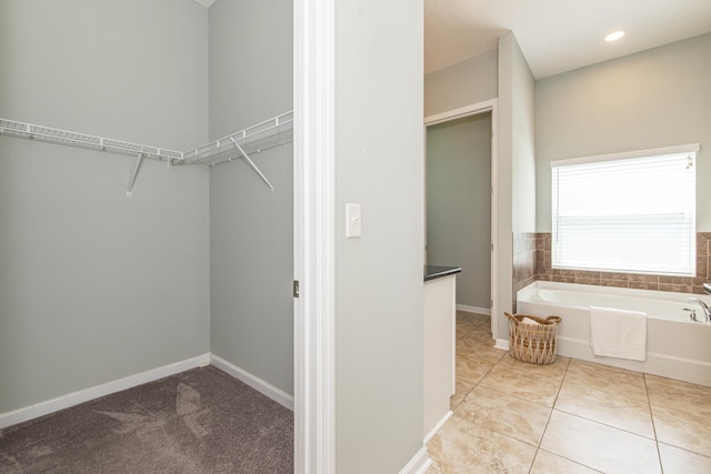 walk in closet with light tile patterned floors