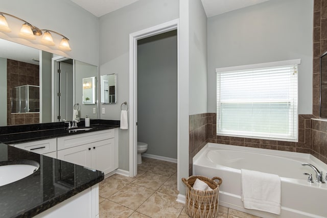 full bathroom with tile patterned floors, separate shower and tub, a textured ceiling, toilet, and vanity