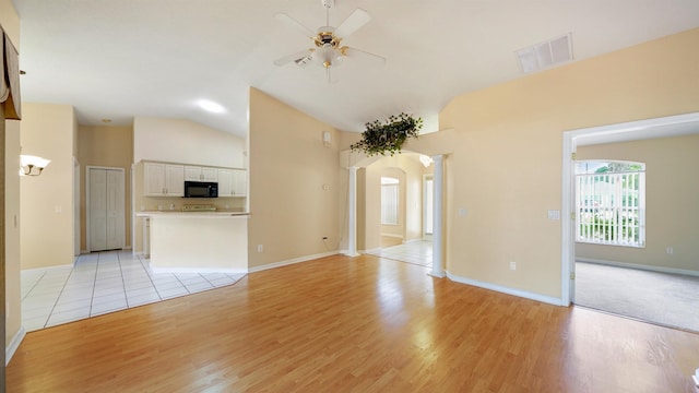 unfurnished living room featuring light wood-style flooring, a ceiling fan, lofted ceiling, and visible vents
