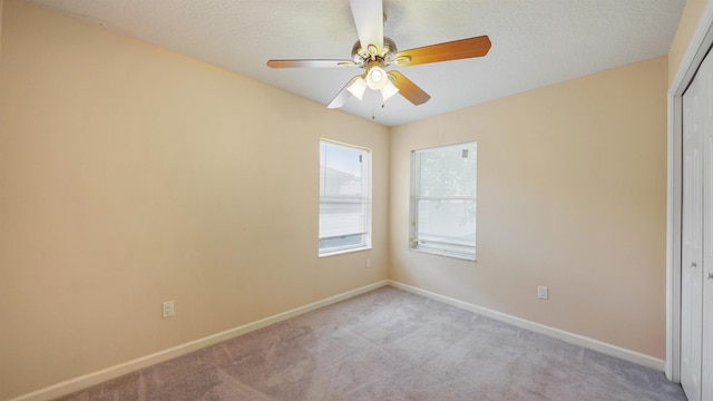 empty room featuring baseboards, light colored carpet, and ceiling fan