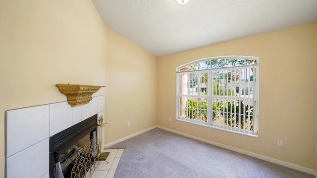 unfurnished living room with light colored carpet, baseboards, vaulted ceiling, and a fireplace