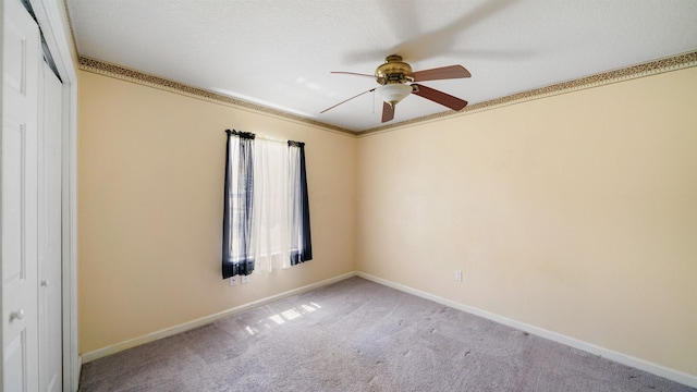 empty room featuring ceiling fan, baseboards, and carpet