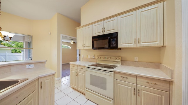 kitchen featuring black microwave, light tile patterned floors, white electric range, and light countertops