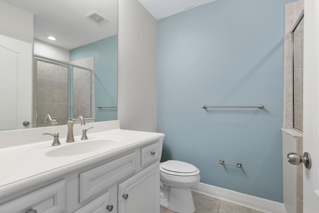 full bath featuring vanity, baseboards, visible vents, a tile shower, and toilet