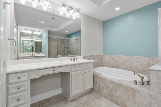 bathroom with tile patterned floors, a textured ceiling, a shower stall, a bath, and vanity