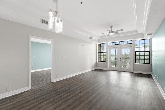 unfurnished room with a raised ceiling, a ceiling fan, visible vents, and dark wood-type flooring