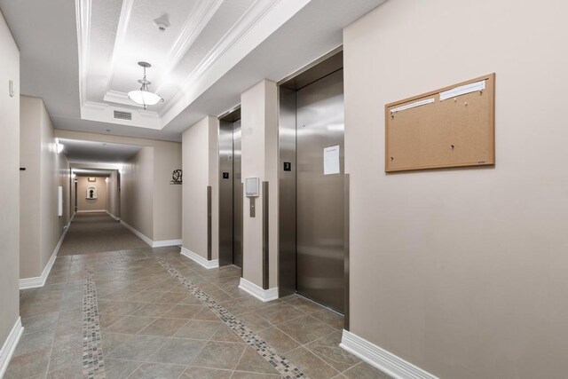 701 Market St Unit 304, Saint Augustine, FL 32095 - corridor featuring elevator, inlaid floor details, a tray ceiling, baseboards, and crown molding