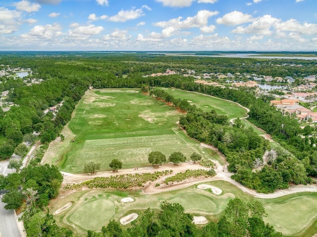 drone / aerial view with view of golf course and a forest view