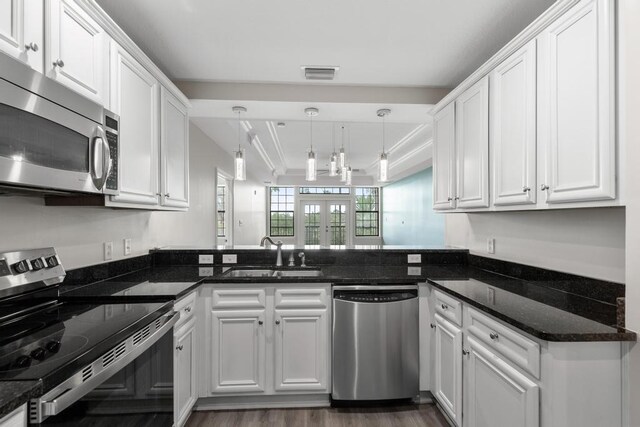 701 Market St Unit 304, Saint Augustine, FL 32095 - kitchen with appliances with stainless steel finishes, a sink, white cabinets, decorative light fixtures, and ornamental molding