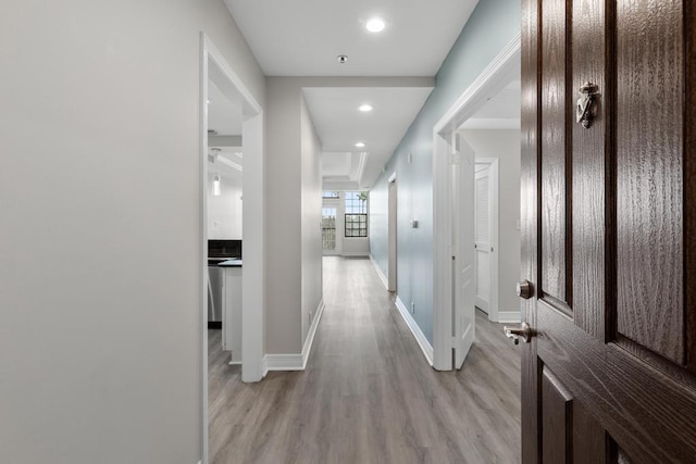 corridor featuring recessed lighting, baseboards, and light wood finished floors