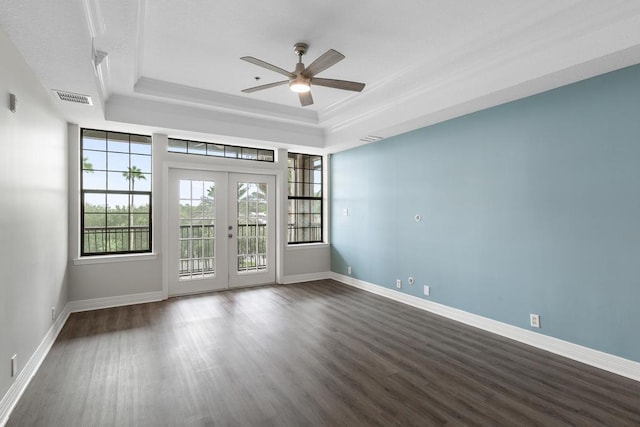 spare room with visible vents, dark wood finished floors, ceiling fan, french doors, and a raised ceiling