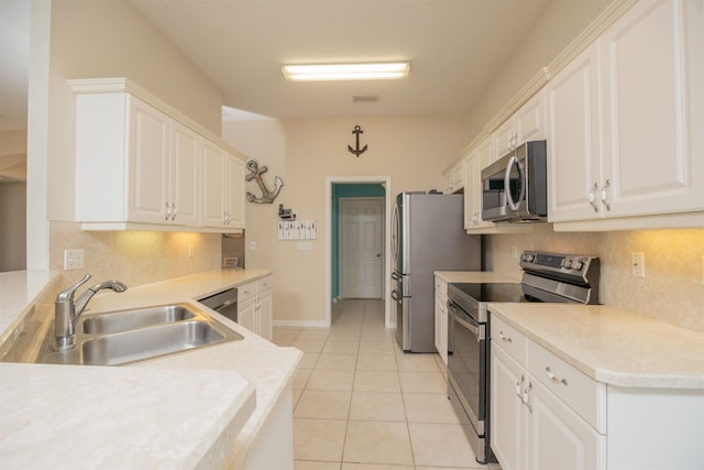 984 Windward Way, Saint Augustine, FL 32080 - kitchen with stainless steel appliances, backsplash, white cabinetry, and light tile patterned flooring