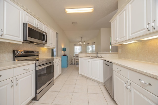984 Windward Way, Saint Augustine, FL 32080 - kitchen featuring stainless steel appliances, backsplash, white cabinetry, and light tile patterned floors