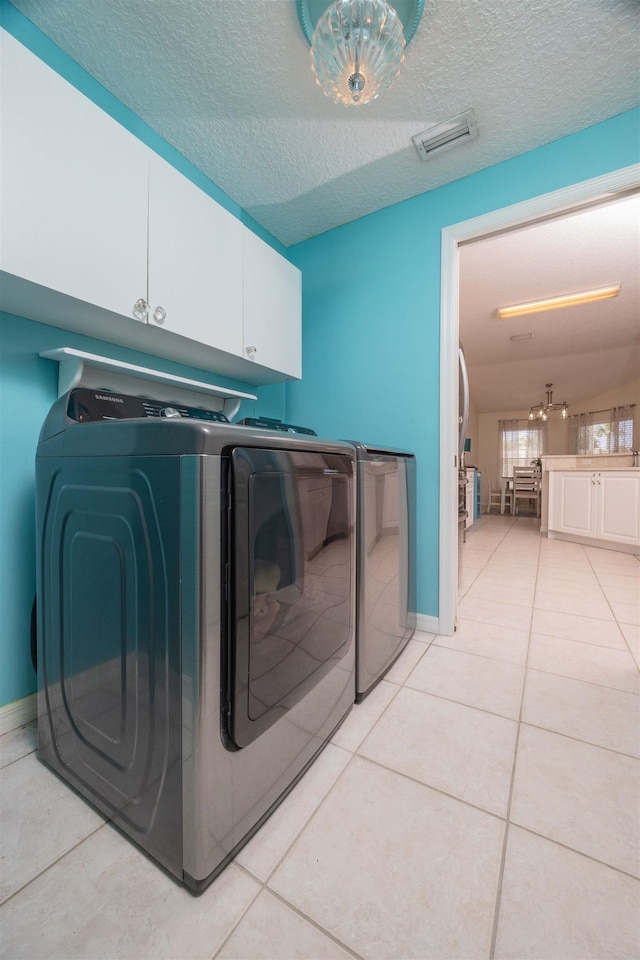 984 Windward Way, Saint Augustine, FL 32080 - laundry area with washer and clothes dryer, cabinet space, light tile patterned floors, and a textured ceiling