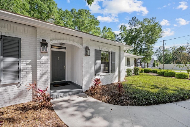 entrance to property with a lawn