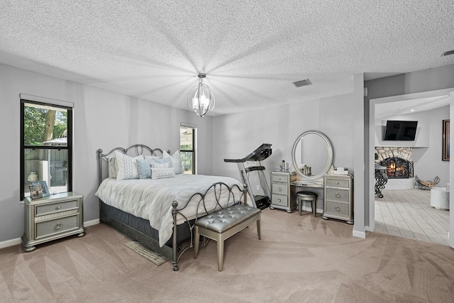 bedroom featuring light carpet, a textured ceiling, and a notable chandelier