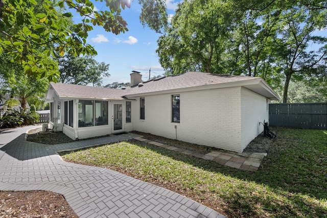 back of property with a sunroom