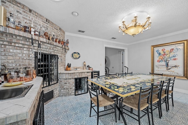 dining room with a textured ceiling, ornamental molding, and sink