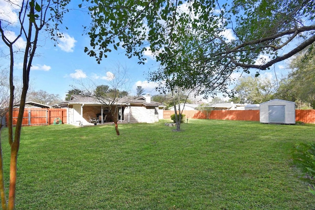 view of yard featuring an outbuilding, a fenced backyard, and a storage shed