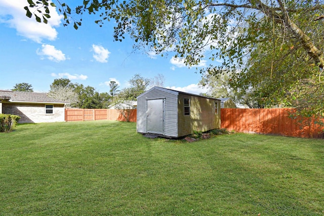 view of yard with a shed, an outdoor structure, and a fenced backyard