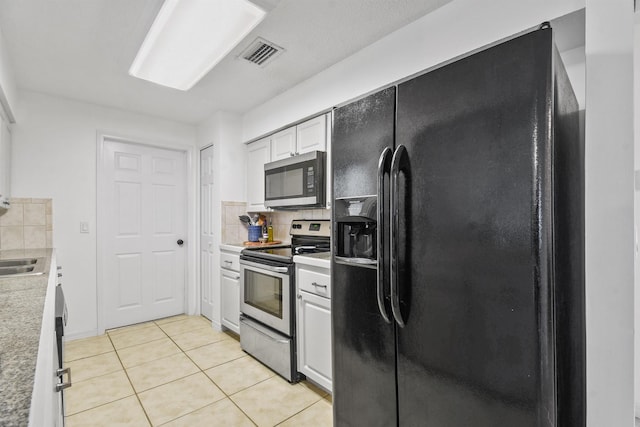 kitchen with light countertops, visible vents, appliances with stainless steel finishes, white cabinets, and light tile patterned flooring