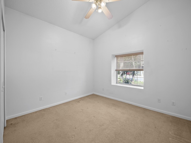 spare room featuring ceiling fan, lofted ceiling, and carpet