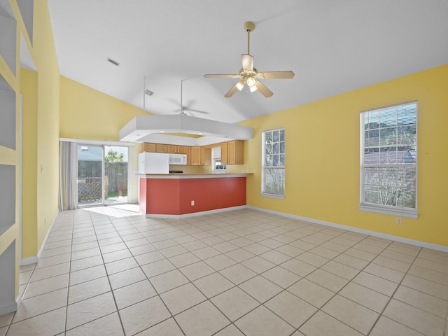 unfurnished living room featuring lofted ceiling, light tile patterned floors, and ceiling fan