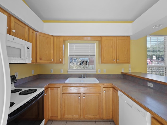 kitchen with sink, a wealth of natural light, white appliances, and kitchen peninsula