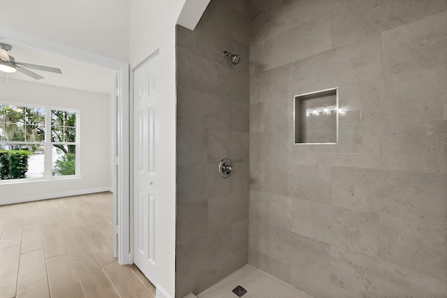 bathroom with ceiling fan and tiled shower