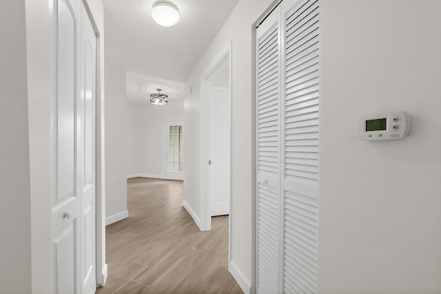 hallway with light hardwood / wood-style flooring