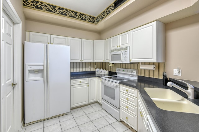 2202 Vista Cove Rd, Saint Augustine, FL 32084 - kitchen with white appliances, a sink, dark countertops, white cabinets, and light tile patterned floors
