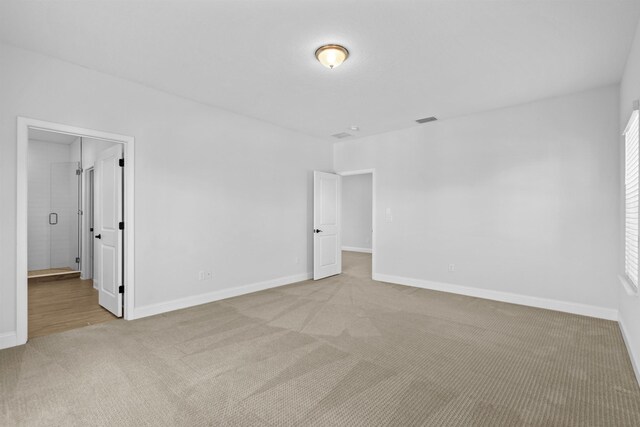 unfurnished bedroom featuring carpet floors, visible vents, and baseboards