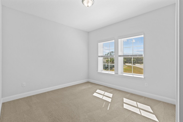 carpeted spare room featuring baseboards