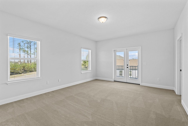 spare room featuring baseboards, french doors, and light colored carpet