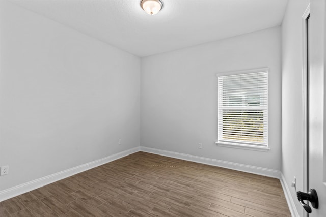 empty room with wood finished floors and baseboards