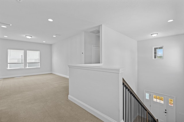 interior space featuring recessed lighting, light colored carpet, and baseboards