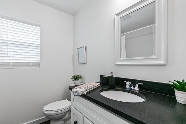 bathroom with a shower with shower curtain, vanity, and toilet