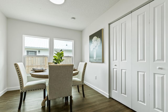 dining room featuring a textured ceiling and dark hardwood / wood-style floors