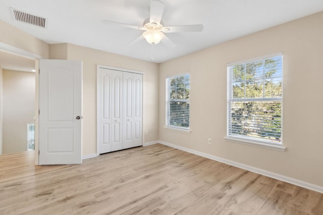 unfurnished bedroom with ceiling fan, a closet, and light hardwood / wood-style flooring