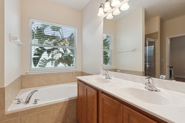 bathroom with vanity, separate shower and tub, and a notable chandelier