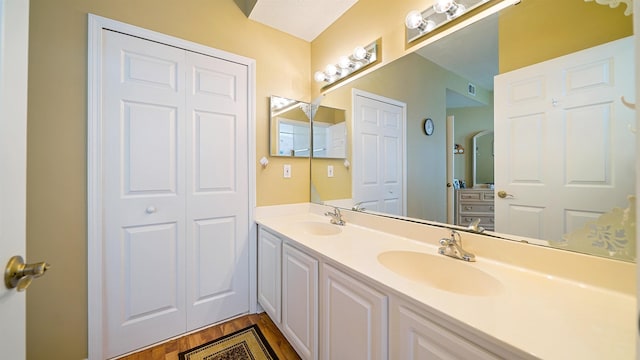 308 Augusta Cir, Saint Augustine, FL 32086 - bathroom with double vanity, a sink, wood finished floors, and visible vents