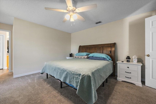 bedroom with ceiling fan, carpet, and a textured ceiling