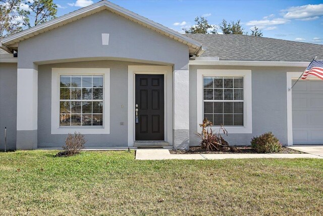 single story home featuring a garage and a front yard