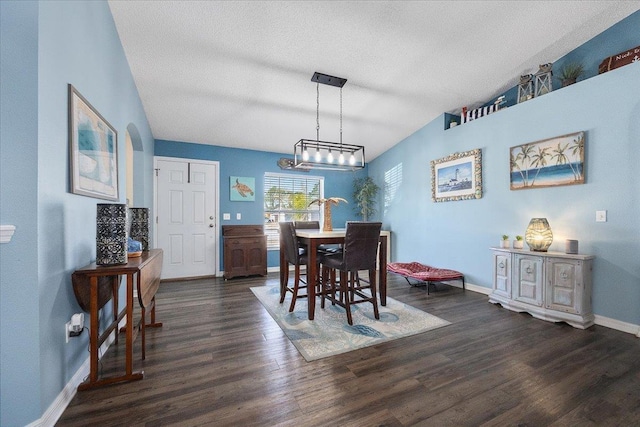 dining area with vaulted ceiling, dark hardwood / wood-style floors, and a textured ceiling