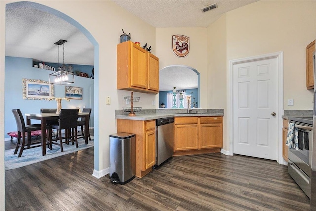 kitchen with dark hardwood / wood-style flooring, decorative light fixtures, stainless steel appliances, and a textured ceiling