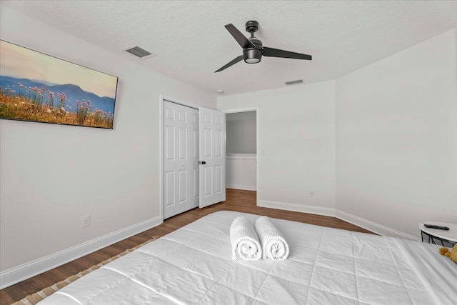 28 S Comares Ave, Saint Augustine, FL 32080 - bedroom featuring wood finished floors, a textured ceiling, baseboards, a ceiling fan, and a closet